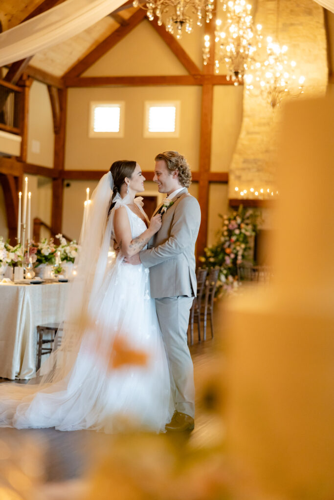 Bride and groom standing behind a wedding cake with romantic decor at The English Barn - taken by a Westchester NY wedding photographer