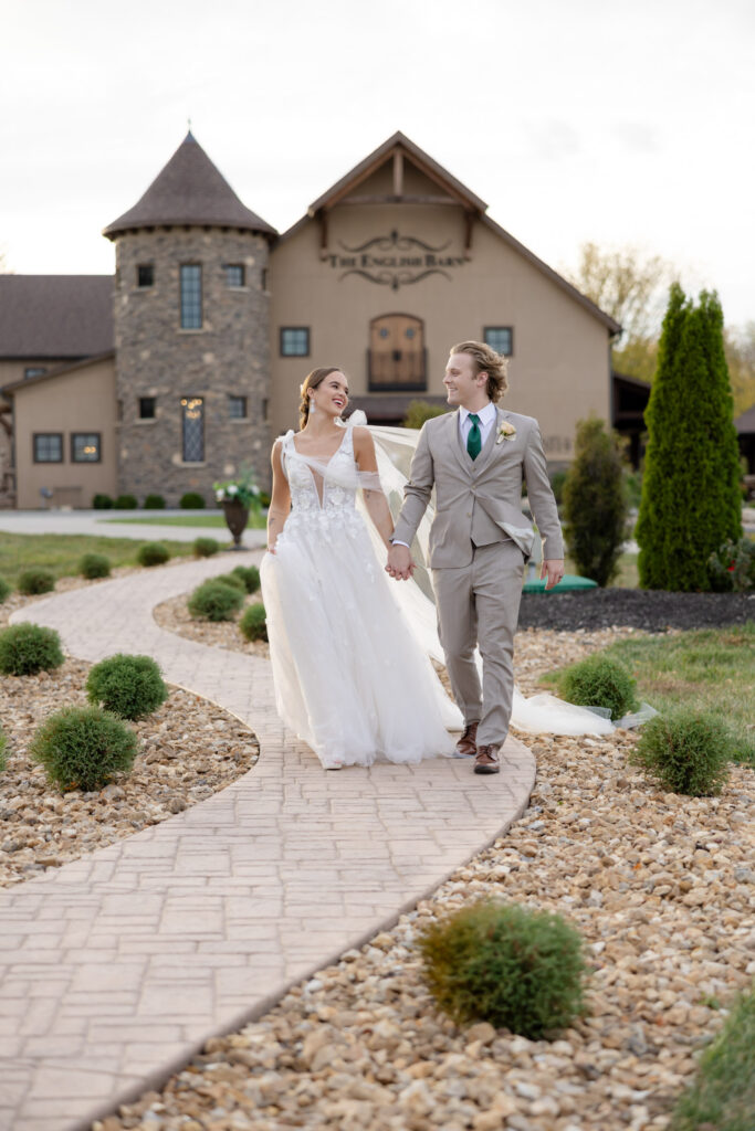 Bride and groom walking hand in hand away from The English Barn wedding venue