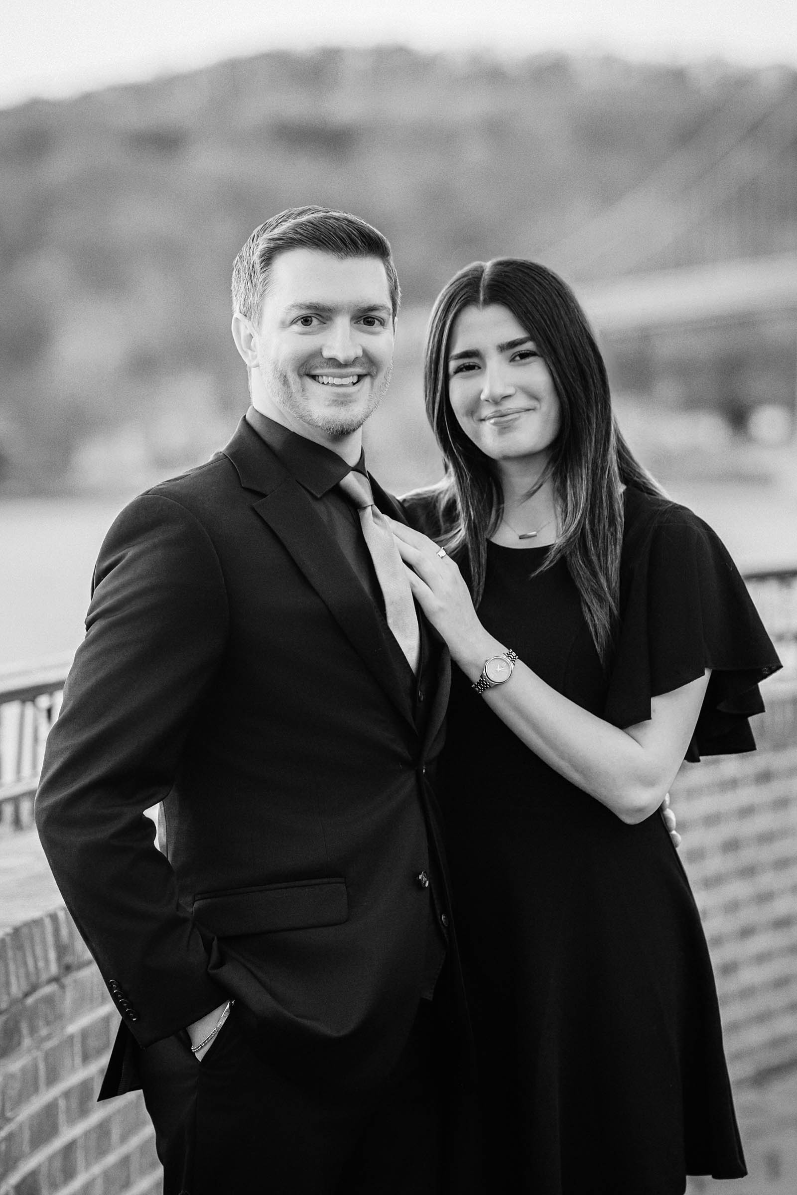 Happy couple in love outside The Grandview in Poughkeepsie, NY with Mid-Hudson Bridge in background; black and white portrait